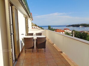 Enjoy the breathtaking sea views from this balcony with a table and two chairs.