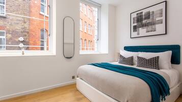 Une chambre moderne avec un lit, une fenêtre et une vue sur la ville.