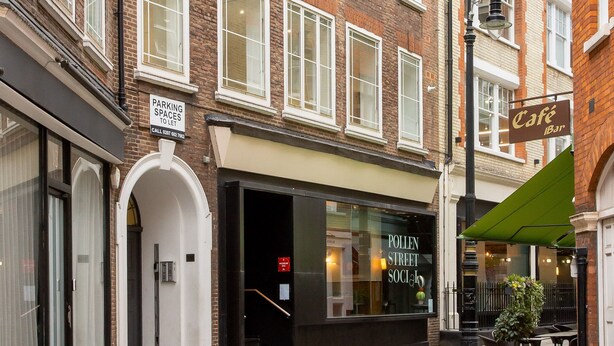 A street view of a building with a café and a sign for parking spaces. - 2 Bed 2 Bath Apartment Off Regent Street (London)