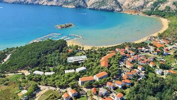 A coastal residential area with houses, a marina, and a beach.