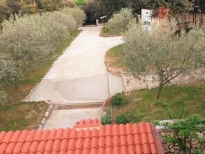 Pathway leads to a simple building surrounded by lush greenery and trees.