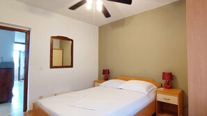 Enjoy a restful stay in this cozy room featuring a single bed, bedside tables, and a ceiling fan.