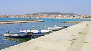 A marina with boats docked, a clear sky, and a distant cityscape. - Apartments Kristina, (15936), Vodice, hr (Vodice)