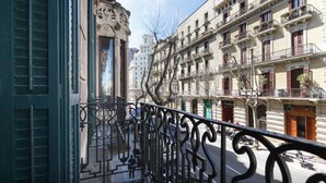 A balcony with ornate metal railings overlooking a street with buildings. - Spacious, very bright and centrally located apartment with AC and fiber optic Wifi (Barcelona)