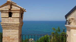 Una torre de piedra con balcón y vistas al mar.