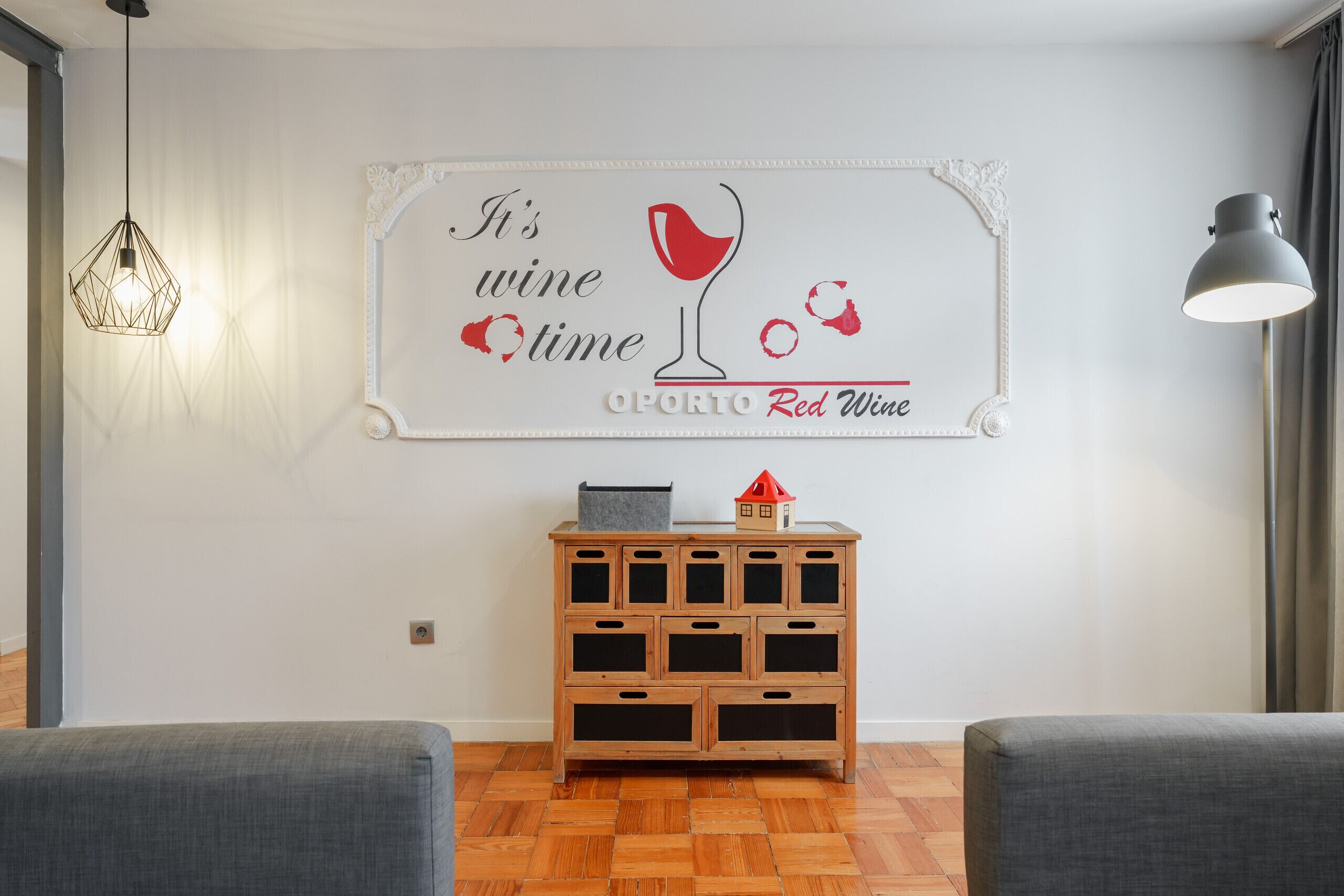 A room with a wooden cabinet, a wall-mounted sign, and two chairs.