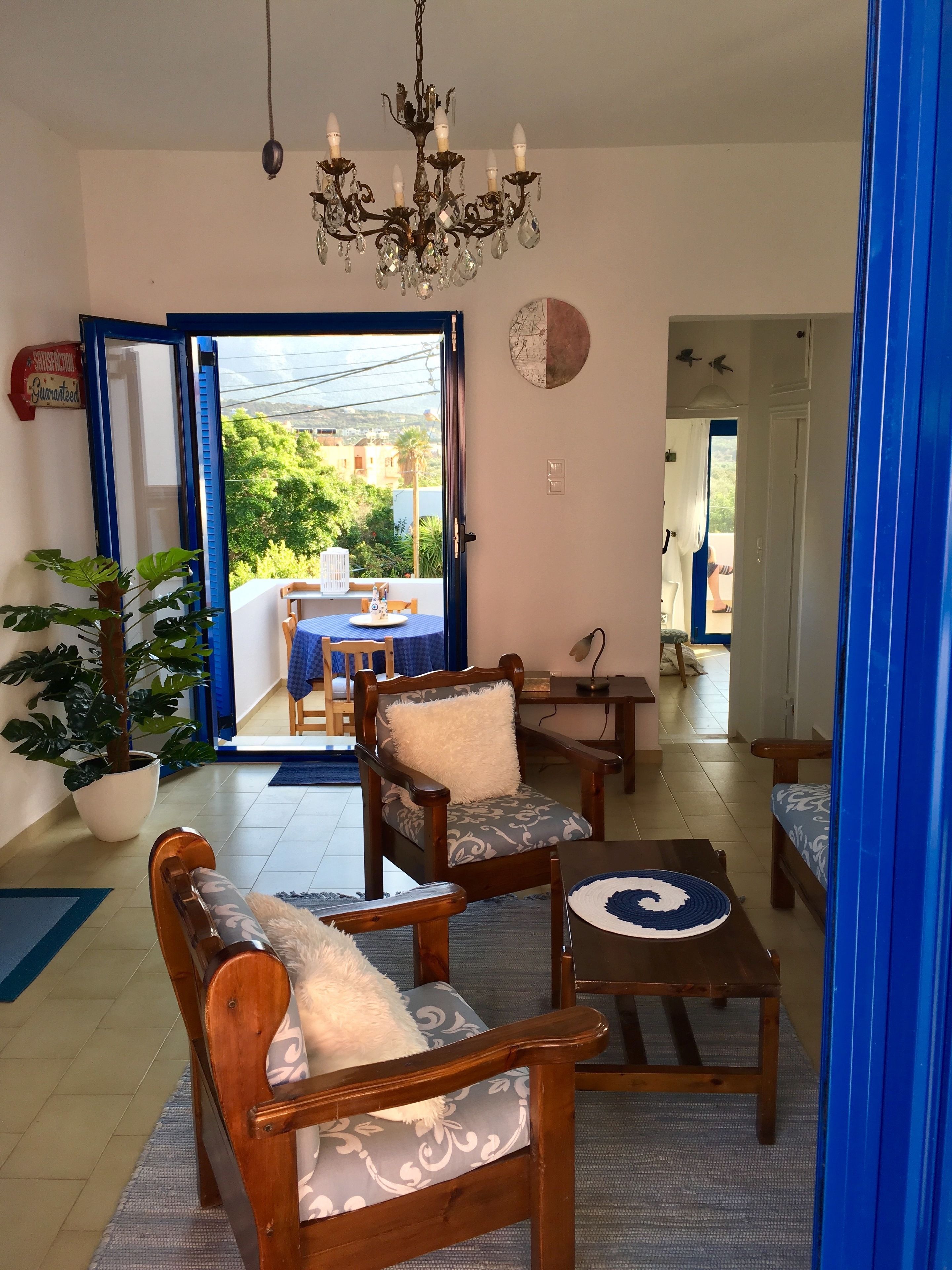 Un salón acogedor con una araña, muebles de madera y vistas al exterior.