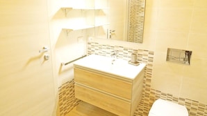 Een badkamer met een witte wastafel, spiegel en toilet.