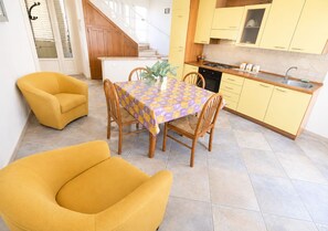 A dining area with a table, chairs, and a plant. - Detached cottage 150 meters from the sea - Maldives of Salento (Torre Vado)