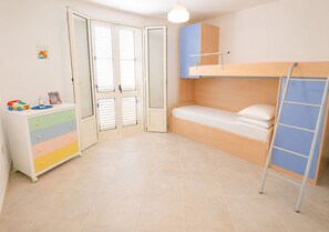 A child's bedroom with a bunk bed, a dresser, and a door with blinds. - Detached cottage 150 meters from the sea - Maldives of Salento (Torre Vado)