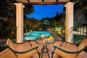 An outdoor patio with a pool, wicker furniture, and a table with fruit and a candle. - Private pool ★ Large garden ★ Wifi ★ 2min drive to beach ★ 3 bedrooms (Galatas)