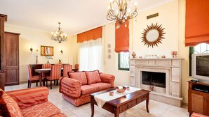 Una sala de estar con chimenea, comedor y televisor.