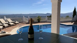 Ein Poolbereich mit einer Flasche Moët & Chandon Champagner und zwei Gläsern, mit Blick auf eine malerische Berglandschaft.