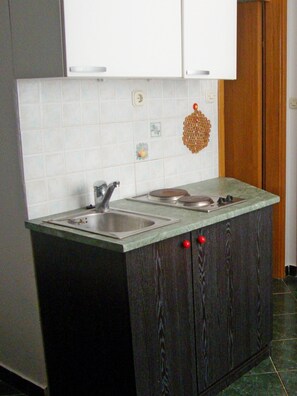 Een koelkast, kookgerei, borden en bestek