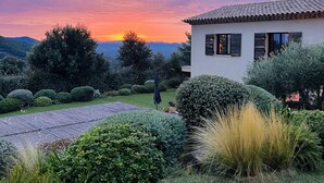 A house with a tiled roof, surrounded by well-maintained hedges and a grassy lawn. - This place is magic in the wonderful village of La Garde Freinet. (La Garde-Freinet)