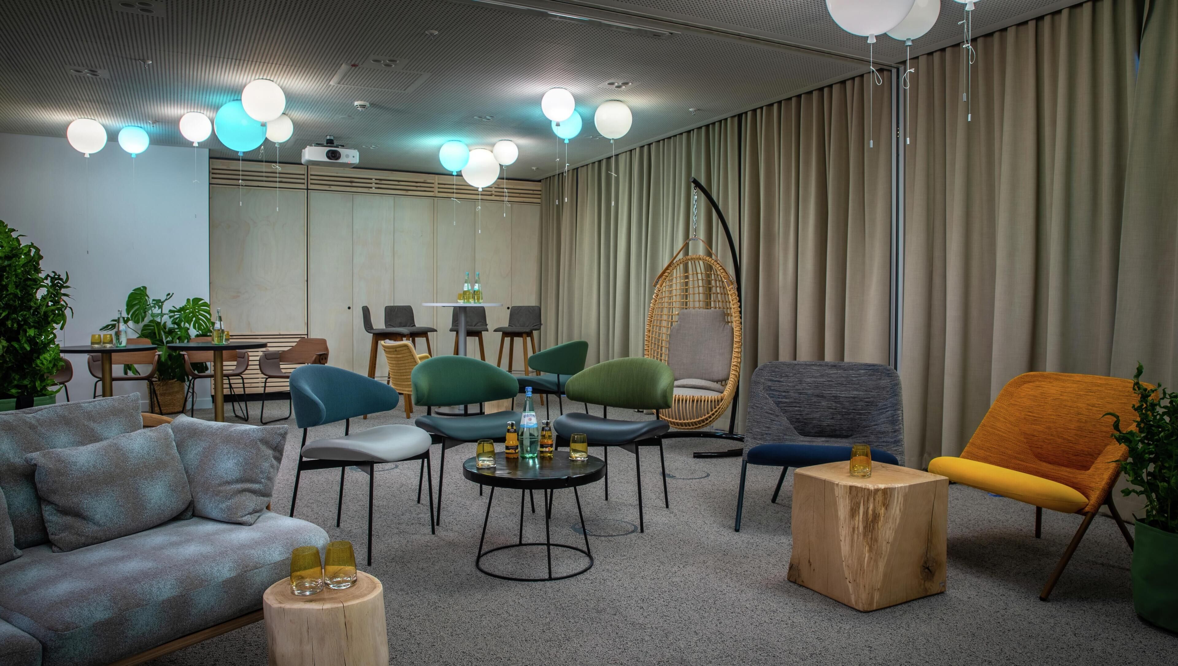 Un salón moderno con sofás, sillones, comedor y un amplio ventanal con cortinas.