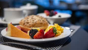 Un plato de desayuno con frutas y un muffin sobre una mesa.