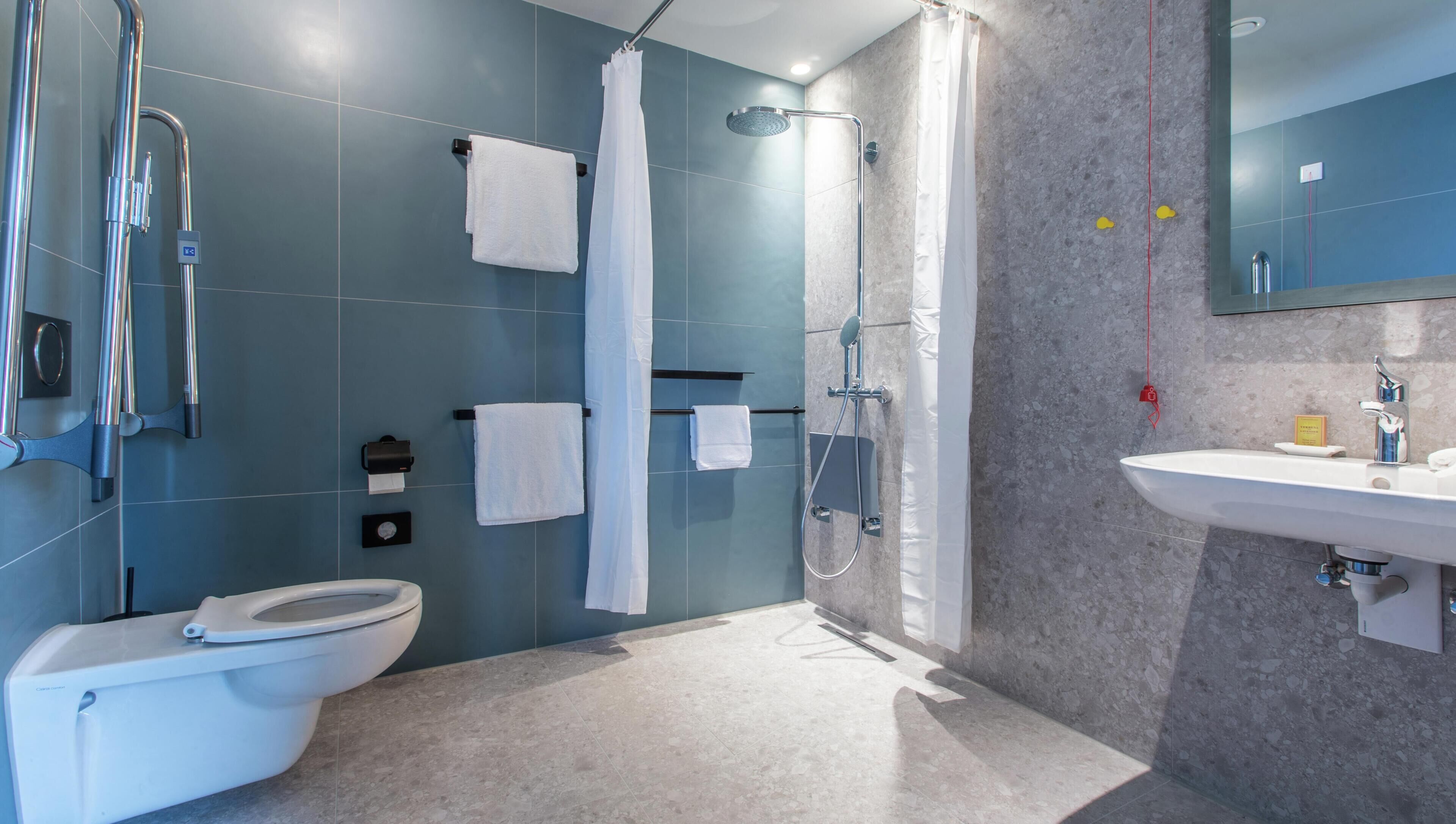 A modern bathroom with a toilet, shower, and sink.