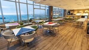Un comedor moderno con amplios ventanales, suelo de madera y muebles contemporáneos.