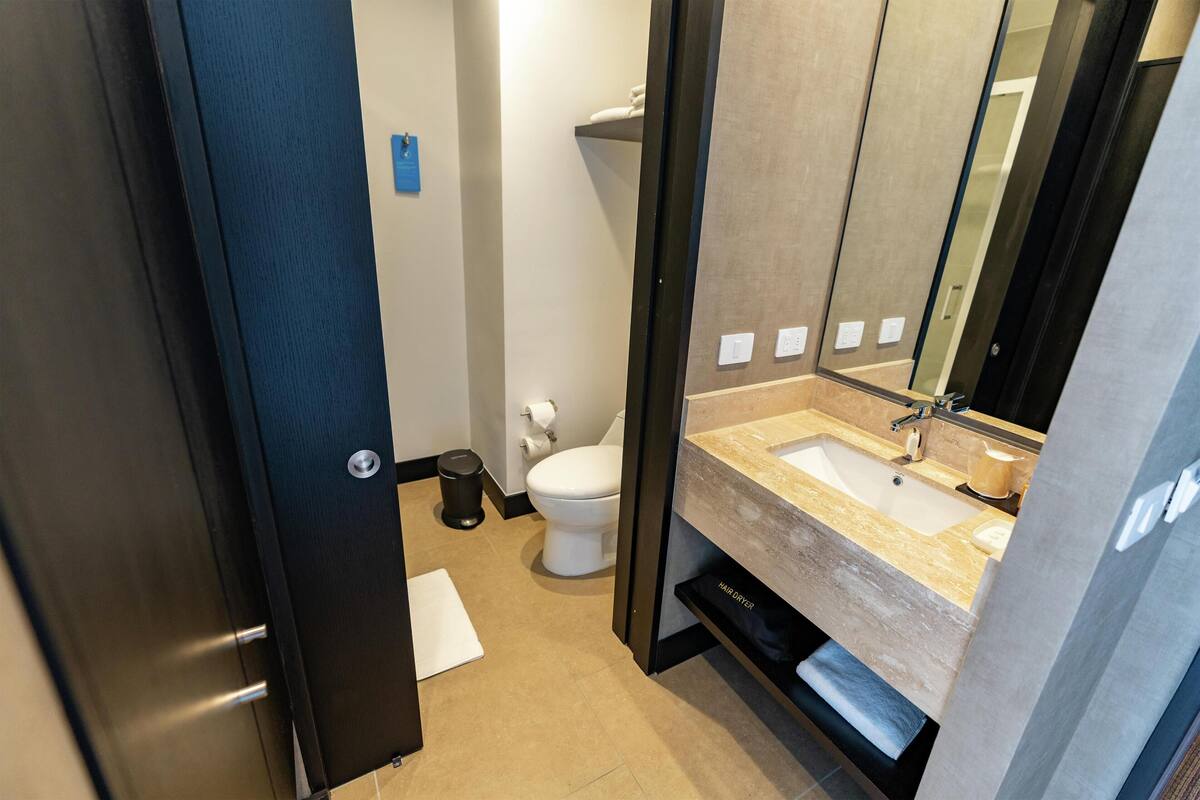 Une salle de bain moderne avec un lavabo, un miroir et des toilettes.