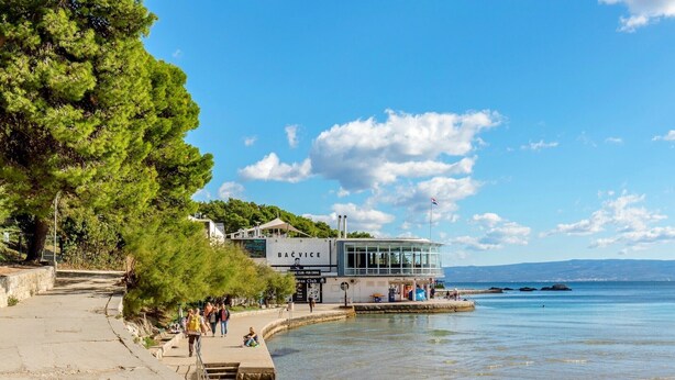 A waterfront building with a glass facade, a flag, and a sign reading "BAČVICE". - Apartments Slavica, (14203), Split, hr (Split)