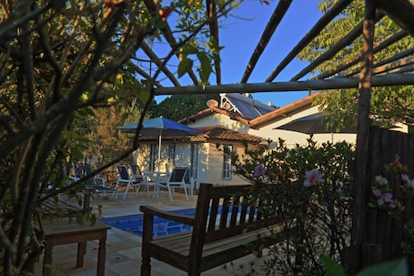 Una piscina al aire libre, sombrillas, sillones reclinables de piscina