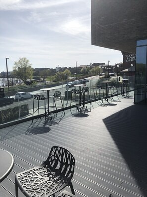 A terrace with outdoor seating, a view of a road, and a building labeled "Stockto. Baptist Church" in the background. - Hampton by Hilton Stockton on Tees (Stockton-on-Tees)