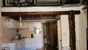 A compact kitchen with white cabinets, a built-in oven, and a hanging light fixture. - House 75m2 air-conditioned + garage, all comforts, located medieval center Cahors. (Cahors)