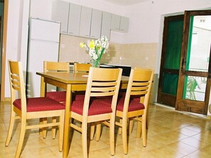 Enjoy meals in this cozy dining area with a wooden table and comfortable seating for four.