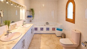 Une salle de bain moderne avec un double vasque, une baignoire et des toilettes.