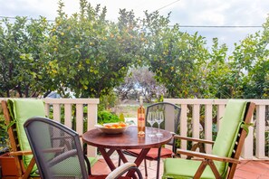 Enjoy a romantic dinner for two in this serene outdoor setting, complete with a table and comfortable seating.