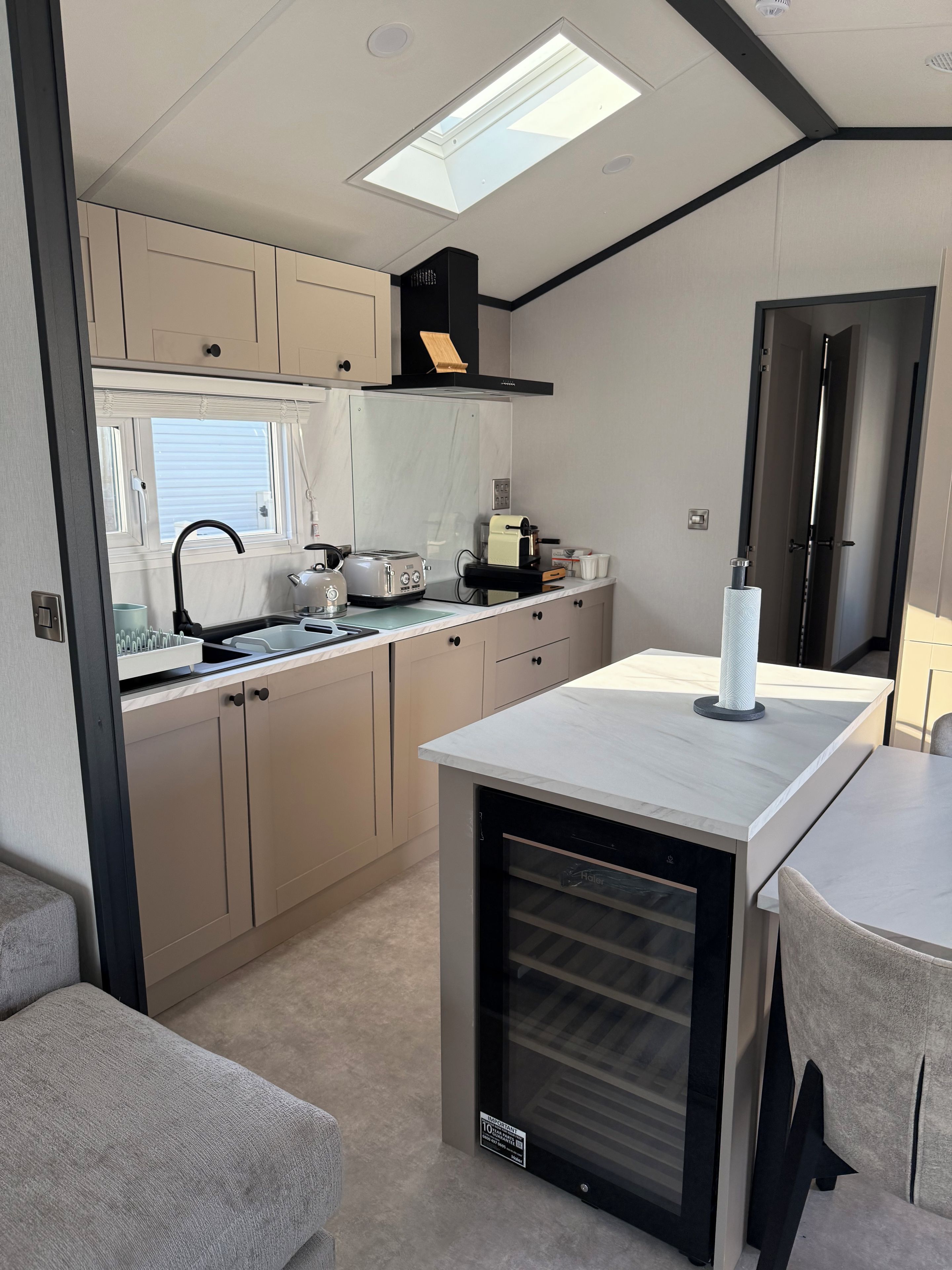 A compact kitchenette with a built-in oven, a sink, and a window above the counter.