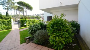 A modern building with a paved pathway and well-maintained greenery. - CALA MONTGO 17 (L'Escala)