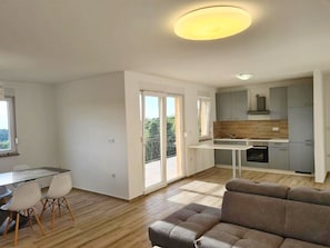Relax in this spacious living area with a comfortable sofa, dining table, and fully equipped kitchen.