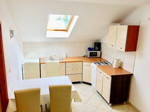Enjoy cooking in this compact kitchen with a gas stove, microwave, and dining area with a table and chairs.