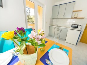 Enjoy meals in the dining area with a view, featuring a table set for a meal and a kitchen area nearby.
