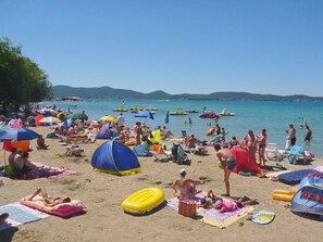 Guests can enjoy a lively beach scene with umbrellas, beach chairs, and a relaxed atmosphere.