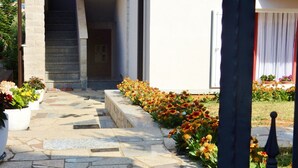 A stone-paved entrance with a staircase leading to a building, surrounded by flower beds. - Apartments Snježana, (15028), Medulin, hr (Medulin)