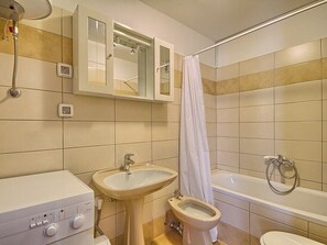 Bathroom features a sink, bidet, bathtub, and showerhead.