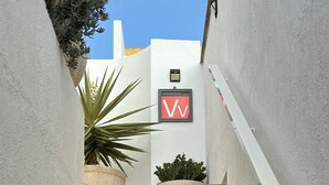 A staircase leading to a building with a white exterior and a red and white sign. - Superior Deluxe Vacation Home with open views Privat sun Terrace & 5G WiFi (municipal de mogan, ARGUINEGUIN)