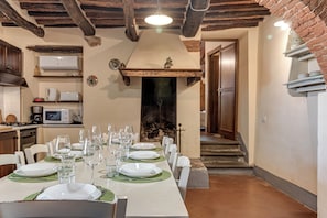 Enjoy meals in this cozy dining area with a long table set for a meal, featuring a microwave and coffee maker nearby.