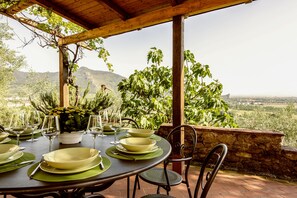 Dine al fresco under a shaded pergola with a view of the surrounding mountains.