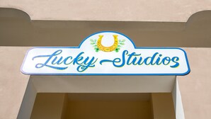 Une enseigne pour Lucky Studios, avec un motif représentant un fer à cheval et un trèfle.