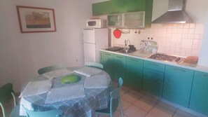 Een koelkast, een microgolfoven, kookgerei, borden en bestek