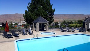 A pool area with lounge chairs, a hot tub, and a gazebo. - Seaport Inn and Suites (Lewiston)