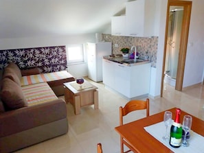Cozy living space with a kitchenette, sofa, and dining table.