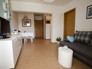 Relax in this stylish living space with a flat-screen TV, comfortable sofa, and dining area.
