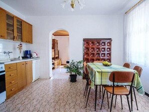 Cozy kitchen and dining space with a kitchenette, dining table, and potted plant.