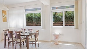 A dining area with a round table, six chairs, and a vase. - Villa Merly, Modern 3BDR Protaras Villa with Pool, Close to Fig Tree Bay Beach (5295)