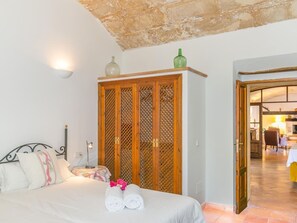Quarto com cama, guarda-roupa e vista para outro espaço.